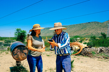 Father using smart phone standing by daughter at farm