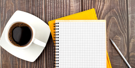 Poster - White cup of hot coffee and notebook on wood table