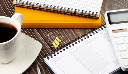 Poster - Wooden table with office supplies,notebooks,planner and coffee, top view