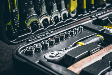 Open Tool-box with many tools. Toolbox a box / container for keeping tools in. Many new wrench and nuts in toolkit sets. Black square plastic workbox. Set of tools in workshop. Tool in case close up.