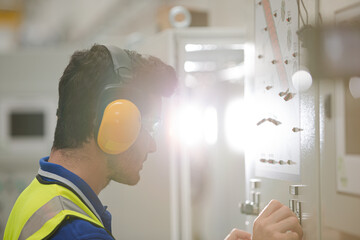 Engineer working at control panel in factory