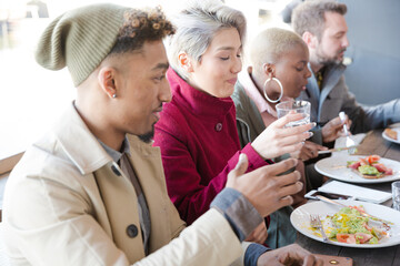 Smiling friends eating at restaurant outdoor patio