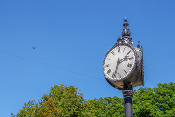 Wall Mural - Metal dial and chairs of a street clock in the park