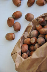Wall Mural - Hazelnut close-up. Hazelnuts in a paper bag on a wooden background. Hazelnut background, healthy food. Corylus. 