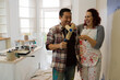 © KOTO - Happy, playful couple with paint rollers painting room