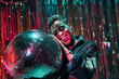 © ADDICTIVE STOCK - Stylish black model with makeup leaning on disco ball