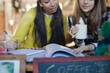 © KOTO - Young female college students studying in cafe