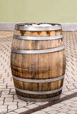 Fototapeta  - brown oak barrel with iron hoops stands in the town square