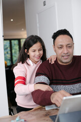 Wall Mural - Father and daughter using digital tablet in kitchen