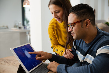 Couple paying bills online, using fingerprint log on at digital tablet