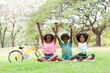 Smiling African American children playing together outdoor. Cheerful kids having fun raising hands in the park. Happy black people, Afro curly hairstyle concept