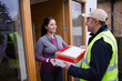 © KOTO - Smiling woman receiving package from deliveryman at front door