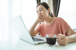 © DG PhotoStock - Young Asian woman bored in online meeting and work from home.