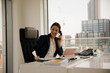 © KOTO - Businesswoman using smartphone in office