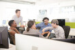 © KOTO - Business people meeting at computer in open plan office