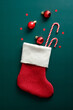 Vintage Santa stocking with candy canes, red balls, and decorations on green background