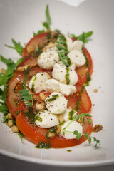 Poster - Vertical shot of a white plate with Caprese salad