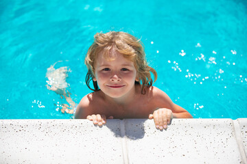 Cute child boy swim in swimming pool, summer water background with copy space. Funny kids face. Kid playing outdoors. Summer vacation and healthy lifestyle concept.