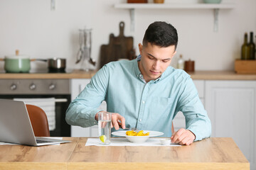 Sticker - Young man eating tasty ravioli at home