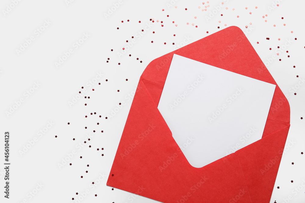 Envelope with blank card and confetti on white background