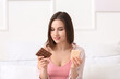 © Pixel-Shot - Beautiful young woman with tasty chocolate at home
