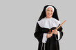 Mature nun with drum sticks on light background