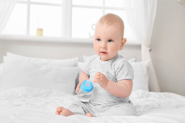 Poster - Cute little baby with bottle of water in bedroom