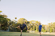 © Austockphoto - horizontal shot of two men playing soccer in the field with one man kicking the ball in mid air
