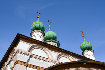 Domes of the ancient Church of the Savior in the provincial town of Solikamsk (Perm Territory, Russia) on a summer morning. Turquoise domes against the blue sky. Embossed masonry walls. 