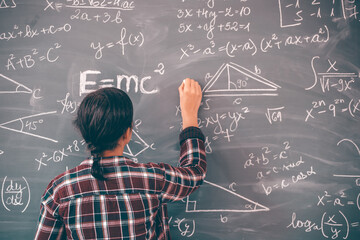 Wall Mural - Teacher or student writing on blackboard during math lesson in school classroom
