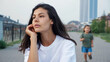 © lenblr - Playful Korean girl runs and jumps on thoughtful mother in white t-shirt back squatting on city embankment in summer evening closeup