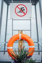 No Swimming Sign And Orange Lifebuoy At The Beach During The Storm