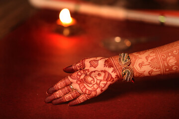 Wall Mural - Beautiful henna or mehendi decoration on a hindu bride's hand & Feet | Isolated hand & feet with diya
Red & Yellow Background