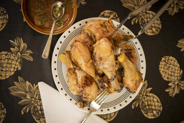 Canvas Print - Top view of a plate of grilled chicken thighs served with sauce