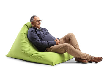 Poster - Relaxed mature man sitting on a green bean bag chair