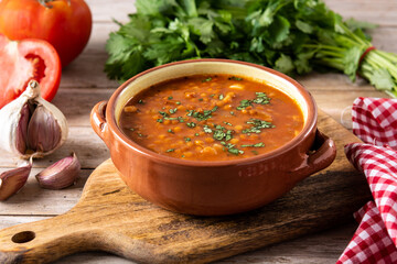 Red lentil soup in bowl on wooden table