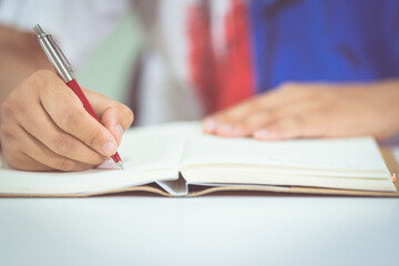 Sticker - Closeup shot of a student writing in a notebook