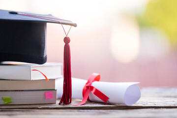 Poster - Closeup shot of a graduation cap and diploma degree certificate on a table