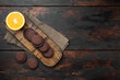 Cookies covered with chocolate and filled with jam, on old dark  wooden table background, top view flat lay, with copy space for text