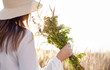 © MAXSHOT_PL - Summer lifestyle portrait of a woman holding a bouquet of field flowers, herbs. She is standing on a field of grass.Happiness and love concept. Copy space