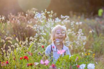 Poster - Cute preschool blond child, playing in the park on sunset, summertime