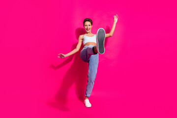 Wall Mural - Full length body size view of attractive cheerful girl having fun showing sole isolated over bright pink magenta color background