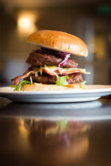 Wall Mural - Delicious classic cheeburger served on a white plate on a wooden table in a restaurant