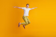 © Tetiana - Portrait of athletic energetic active guy jump pretend airplane hands wings on yellow background