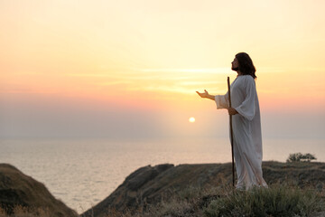 Wall Mural - Jesus Christ on hills at sunset. Space for text