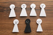 Flat lay composition with black and white paper figures on wooden table. Racism concept