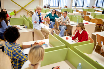 Wall Mural - Students enjoying relaxed lecture by female professor. Smart young people study at the college. Education, college, university, learning and multiethnic people concept