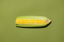 Fresh Corn Cob On Green Background. Ripe Corn Vegetables