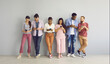 © Studio Romantic - Indoor shot of diverse international group of happy young millennial people leaning on wall, looking at screens of mobile phones, connecting to free wi fi, using messengers, watching online streams