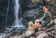 © Soloviova Liudmyla - Smiling Female dog owner and his friend beagle dog resting near the mountain river waterfall during their together walking in autumn season time. Human and pets or walking in nature concept image.